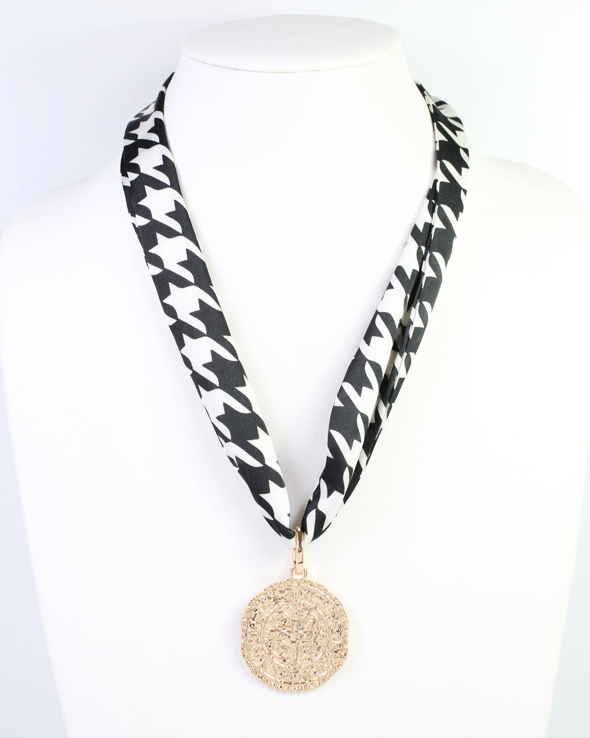 Black and white houndstooth skinny scarf worn as necklace with gold medallion pendant