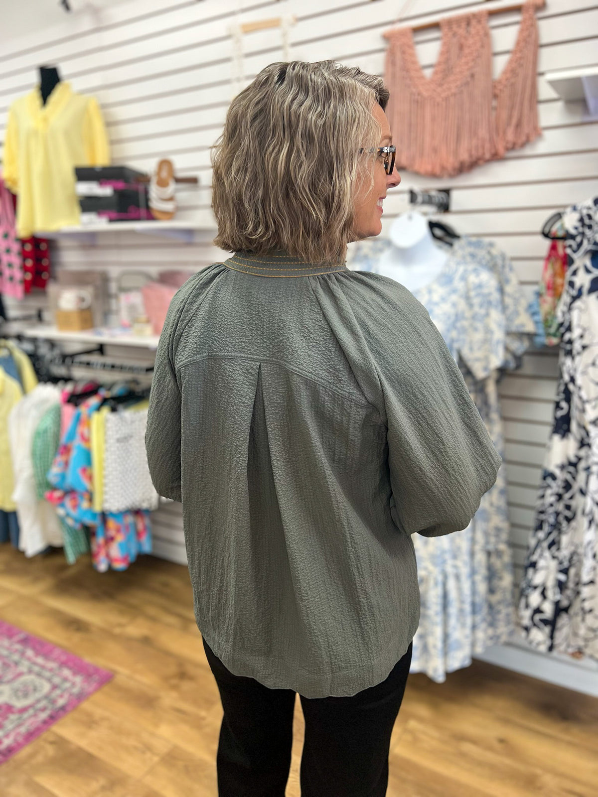 Olive grey textured v-neck top with 3/4 balloon sleeves, back view