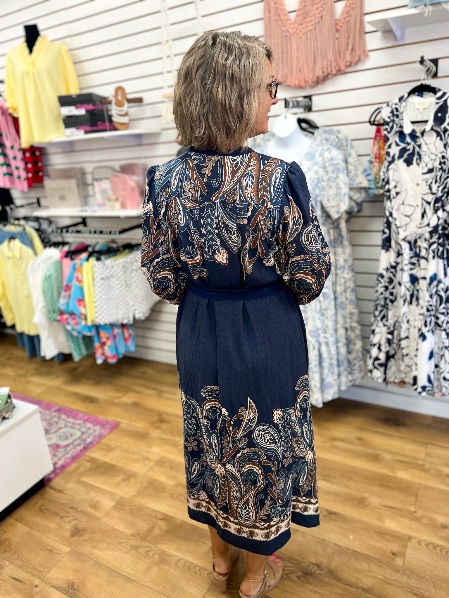 Navy paisley print midi dress with long sleeves and tied waist, back view