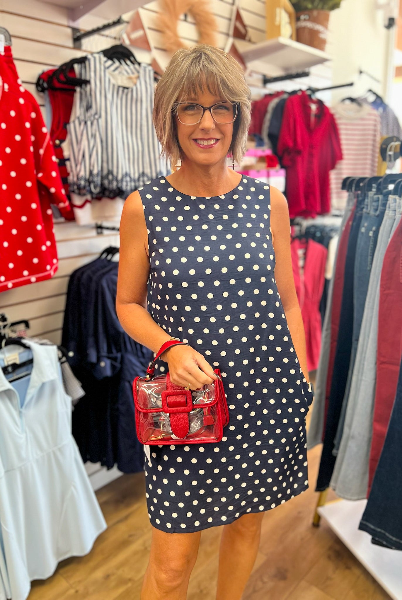 Navy blue sleeveless shift dress with white polka dots and pockets by She + Sky