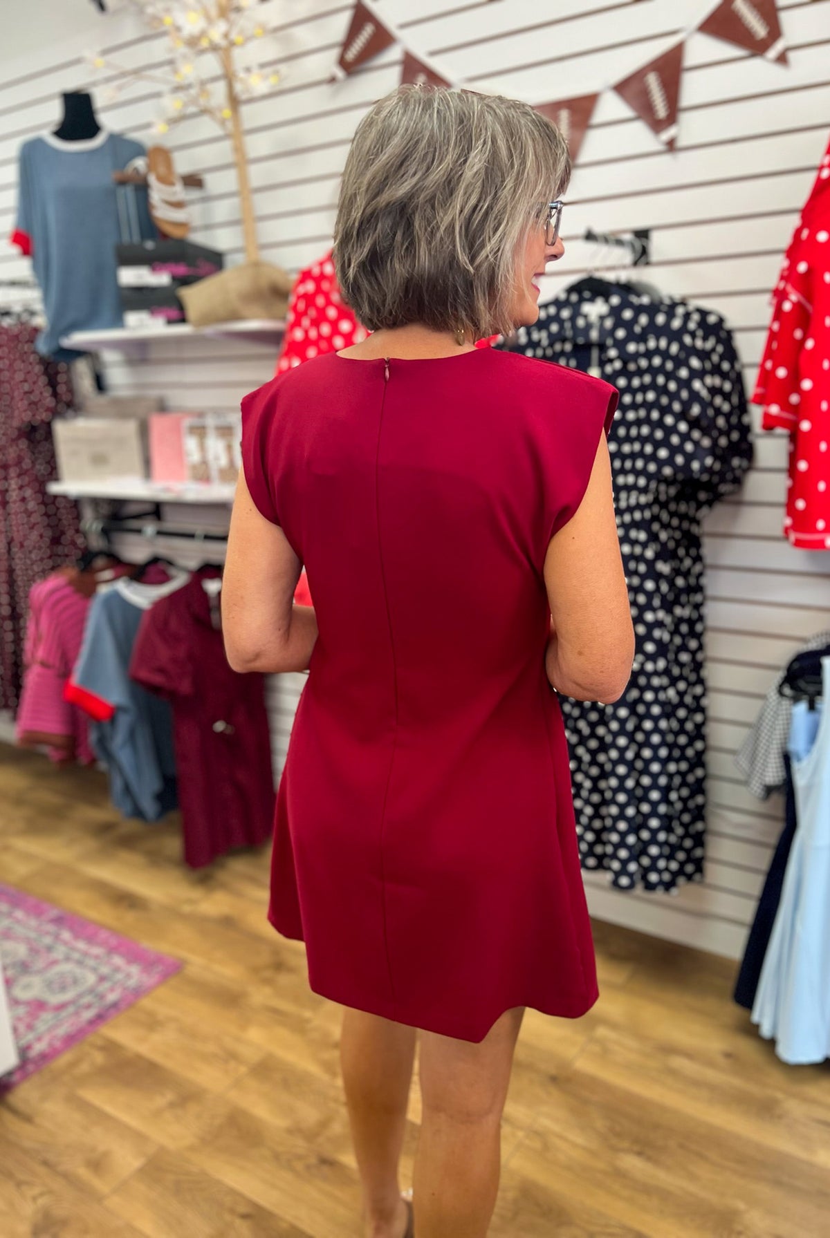 Burgundy sleeveless A-line mini dress with structured shoulders, back zipper closure