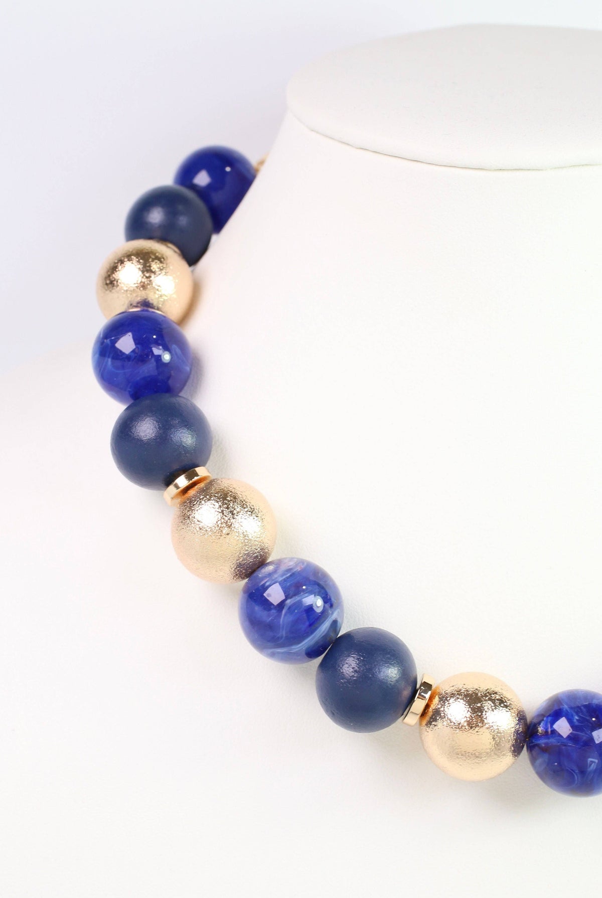 Caroline Hill Elaine navy blue and gold beaded ball statement necklace on display