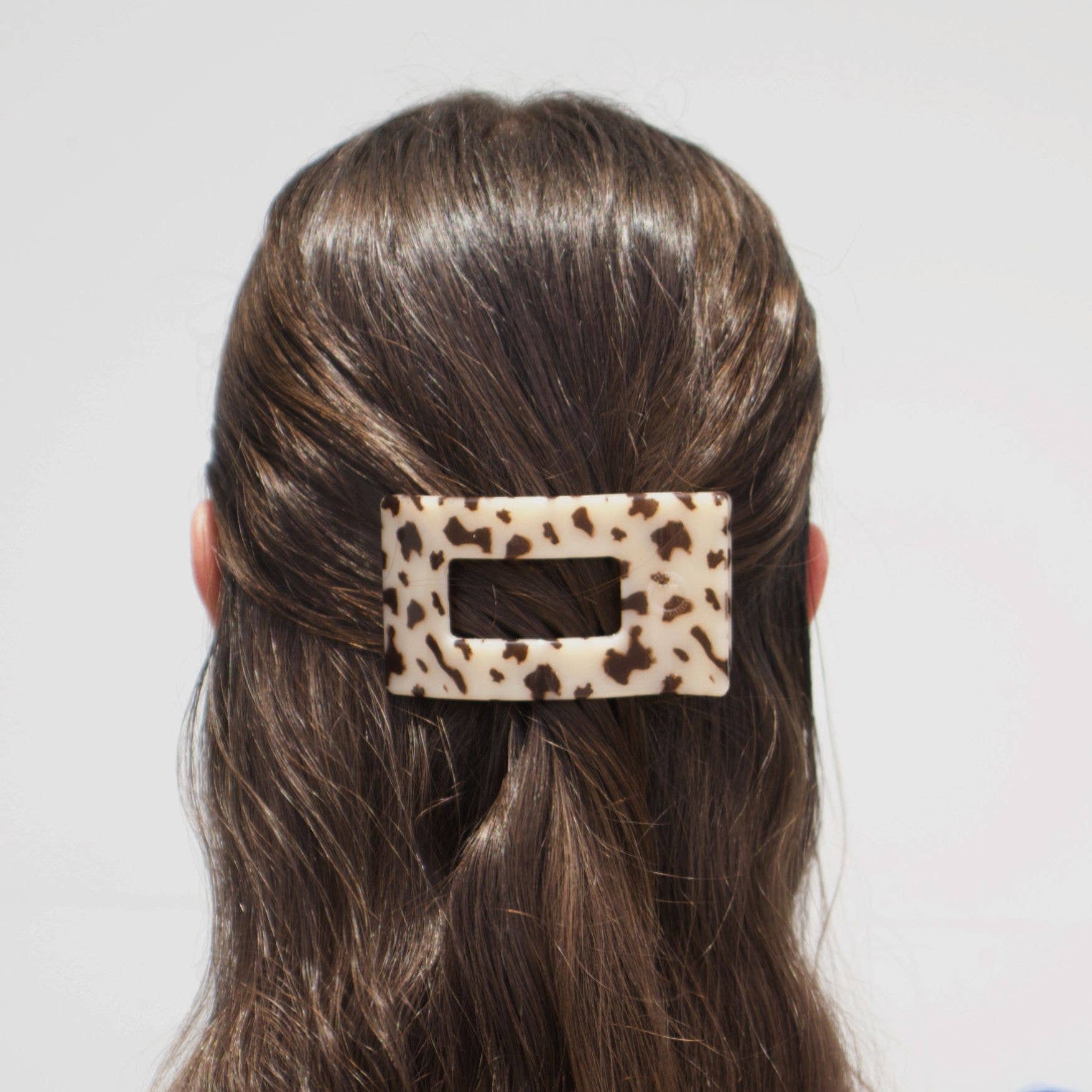 Small rectangular blonde tortoise acetate hair clip worn in half-up hairstyle
