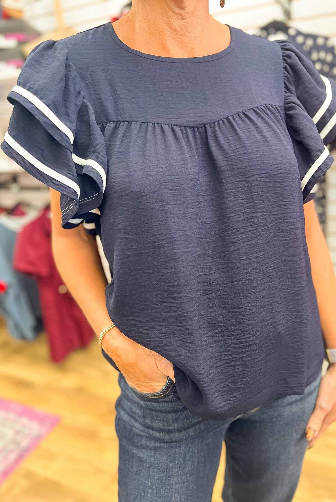 Navy blue ruffle short sleeve top with white contrast piping stripe detail