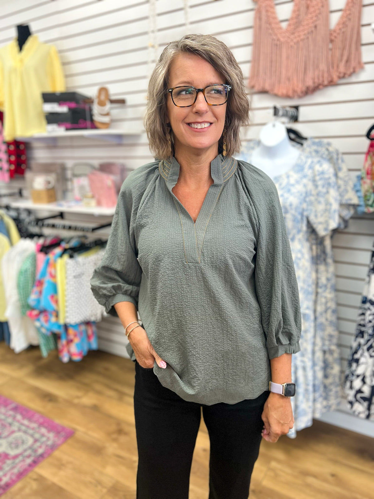 Olive grey V-neck blouse with 3/4 balloon sleeves and contrast stitching on model