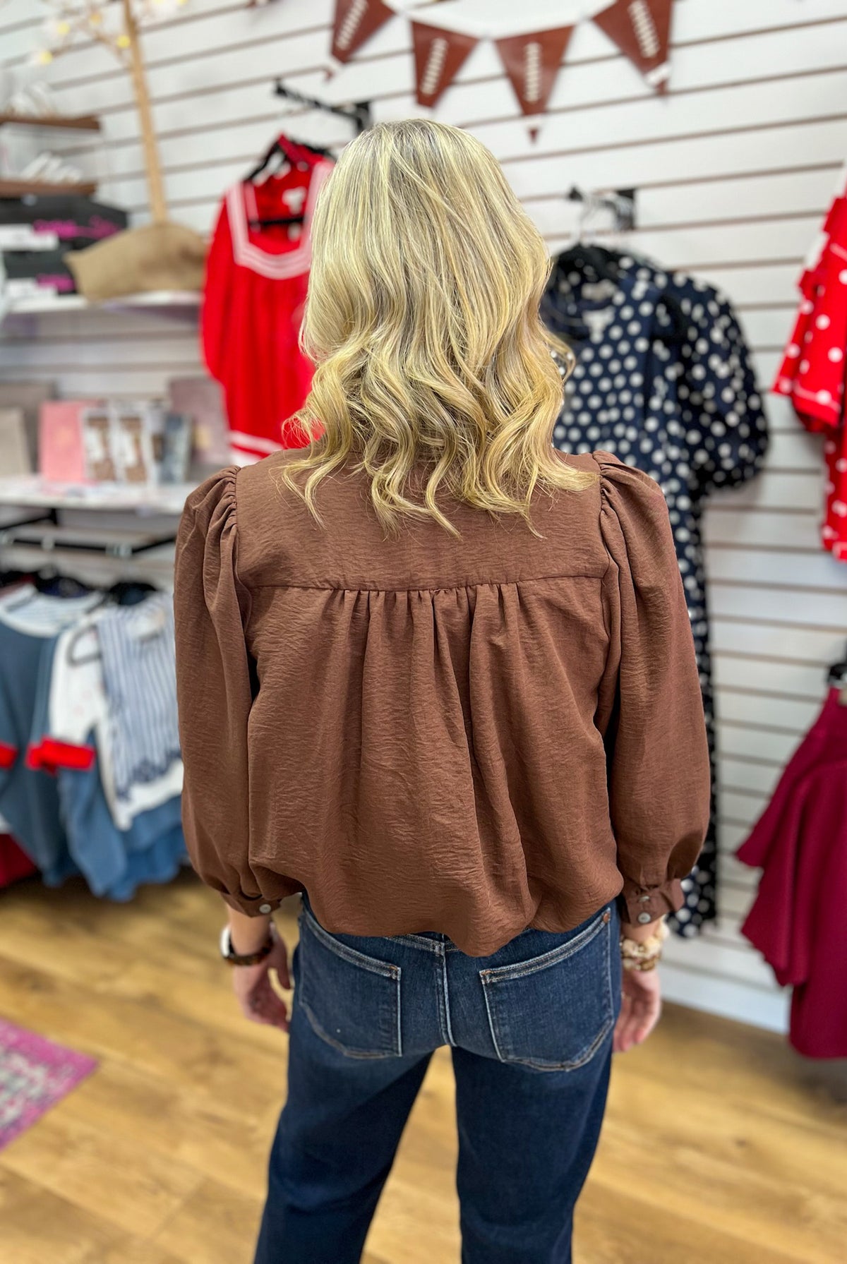 Brown puff sleeve bubble hem top with gathered back detail, worn with jeans