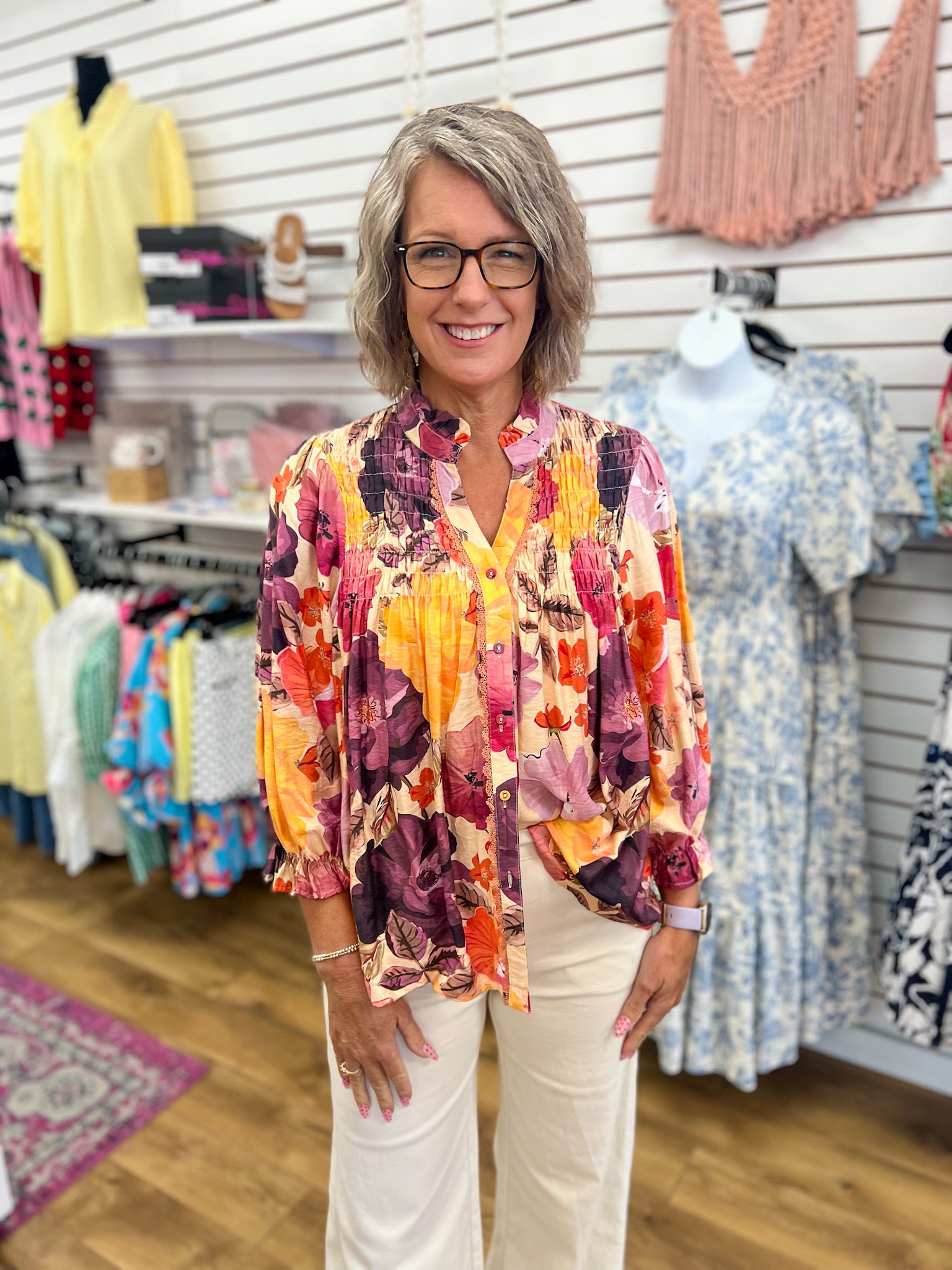 Ecru floral smocked V-neck button-up top with purple and orange blooms