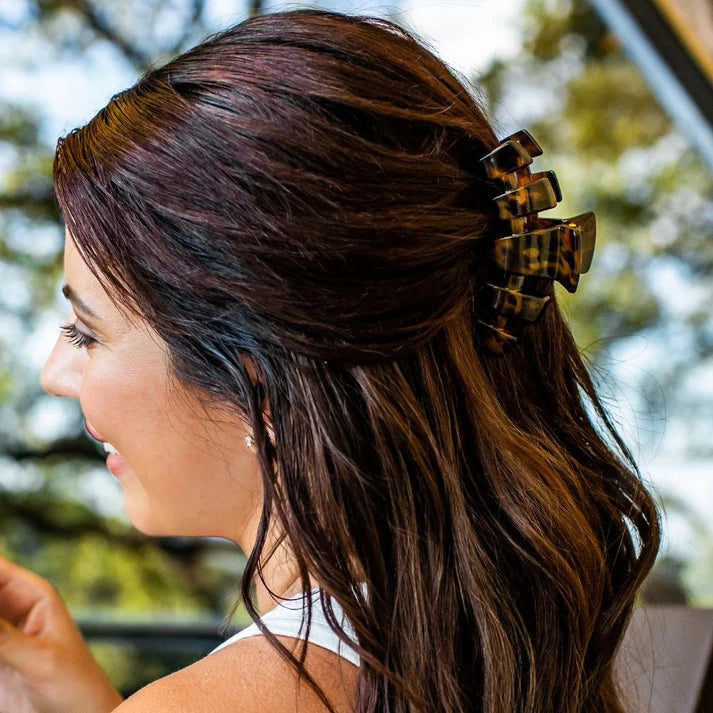 Tortoise shell medium claw clip securing dark brown hair in half-up style