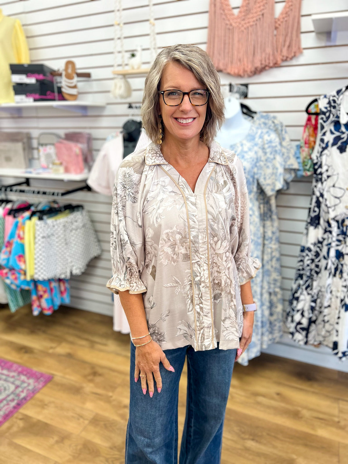 Taupe floral print blouse with 3/4 puff sleeves, contrast trim, and V-neckline