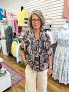 Black paisley boho top with 3/4 sleeves, split V-neckline, and flowy silhouette