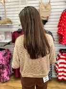Light taupe marled short sleeve knit top shown from the back on model