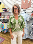 Olive green boho border print top with 3/4 balloon sleeves and tie neckline