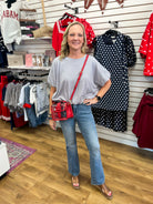 Grey mini checkered bubble hem top styled with jeans and red crossbody bag