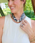 Black and ivory zebra print scarf necklace with large magnetic pearl closure on woman