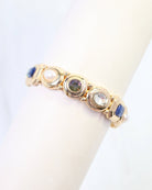 Gold stretch bracelet with blue, green, clear crystal and pearl bezel-set stones