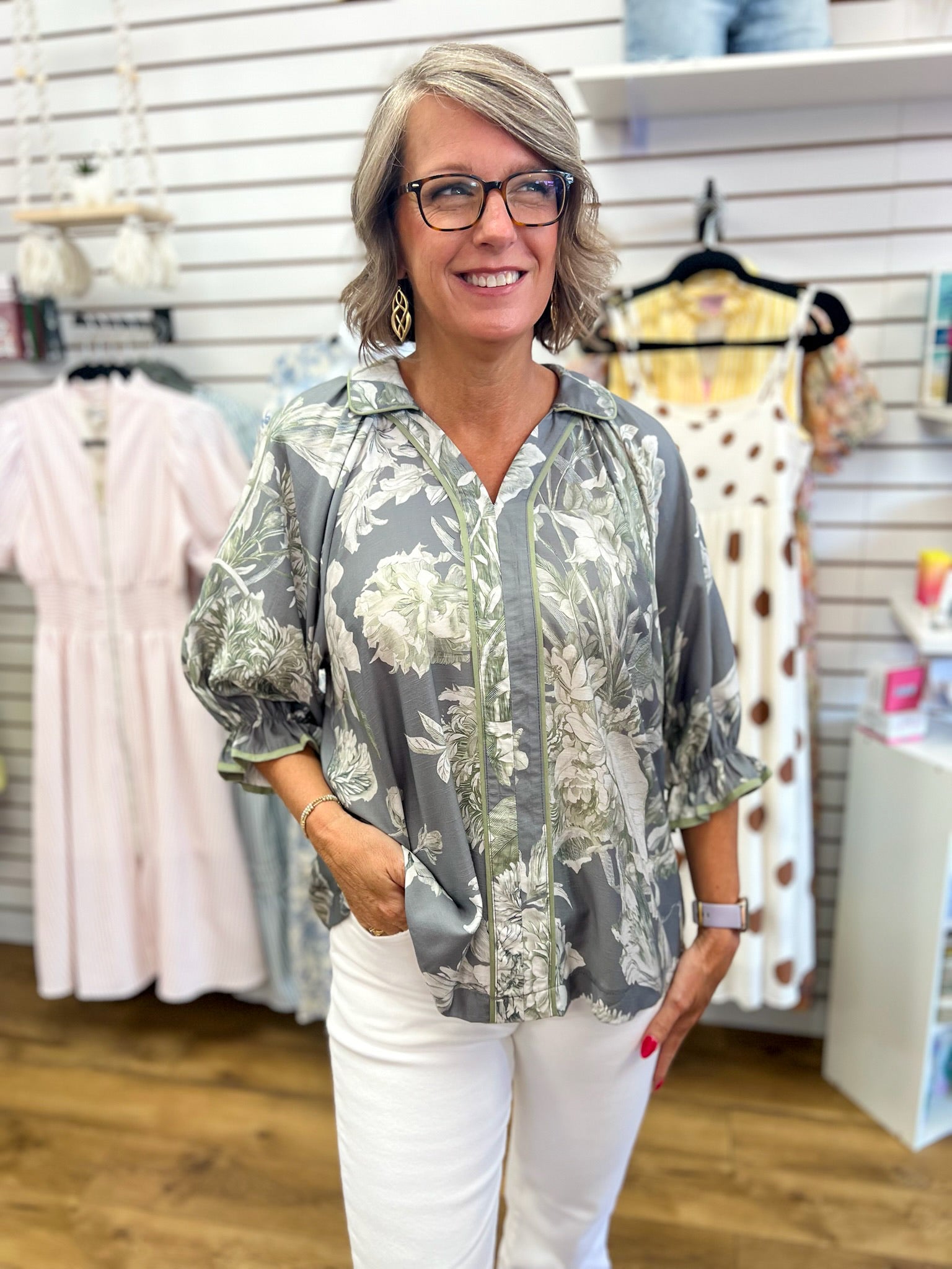 Grey floral print blouse with 3/4 puff sleeves and contrast trim on white jeans
