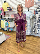 Plum paisley print midi dress with tie waist and V-neck on woman