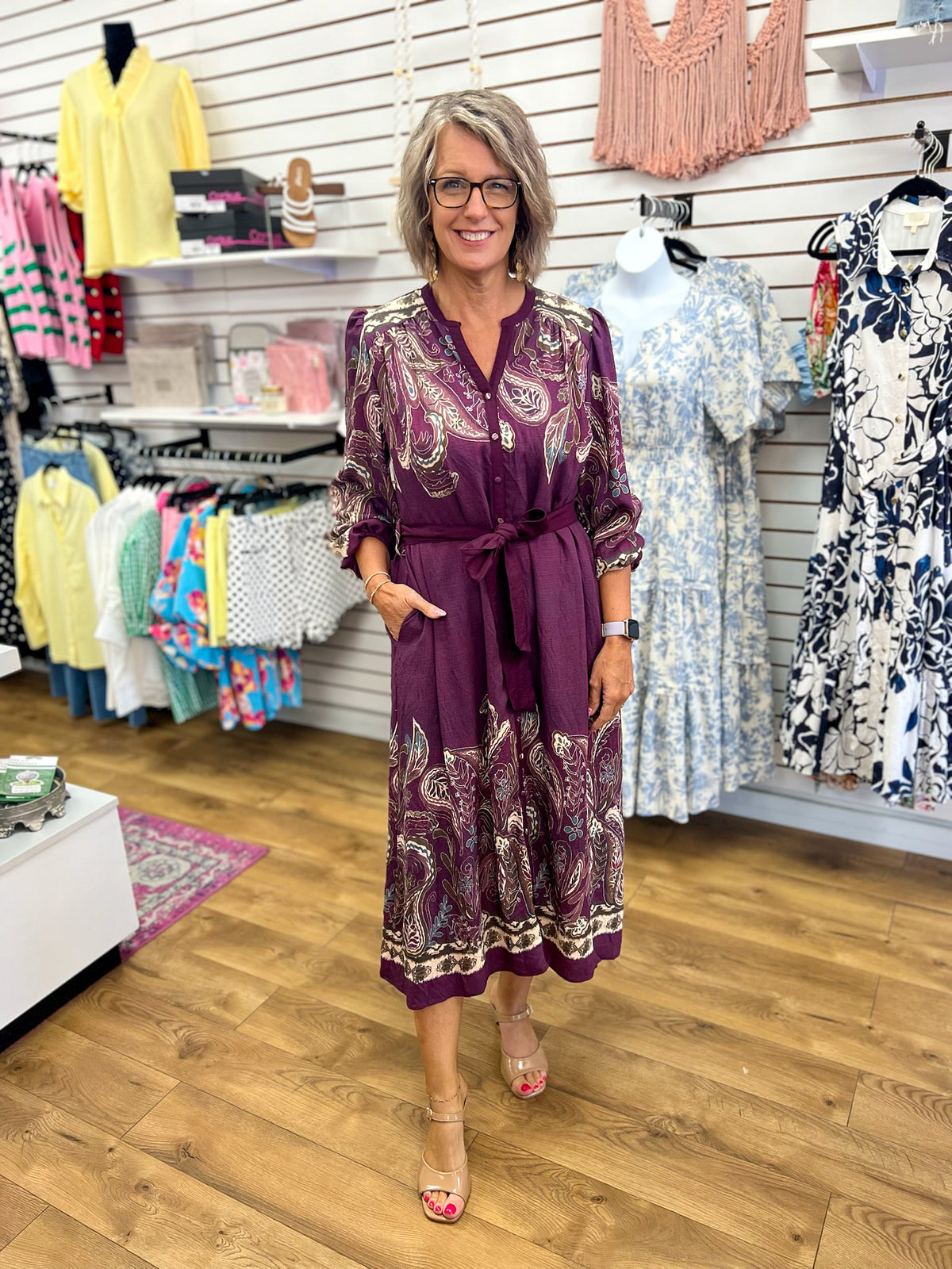 Plum paisley print midi dress with tie waist and V-neck on woman