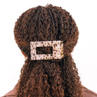 Blonde tortoise rectangular hair clip holding curly brown hair in a half-up style