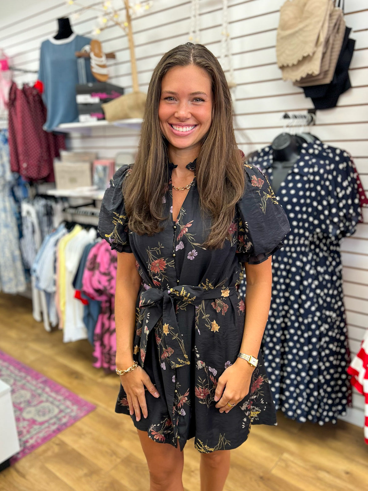 Black floral mini dress with puff sleeves, tie waist, and button-front v-neckline