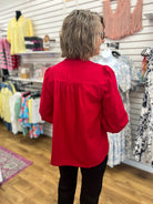 Crimson red Umgee blouse with smocked yoke, ruffle trim, and balloon sleeves, back view