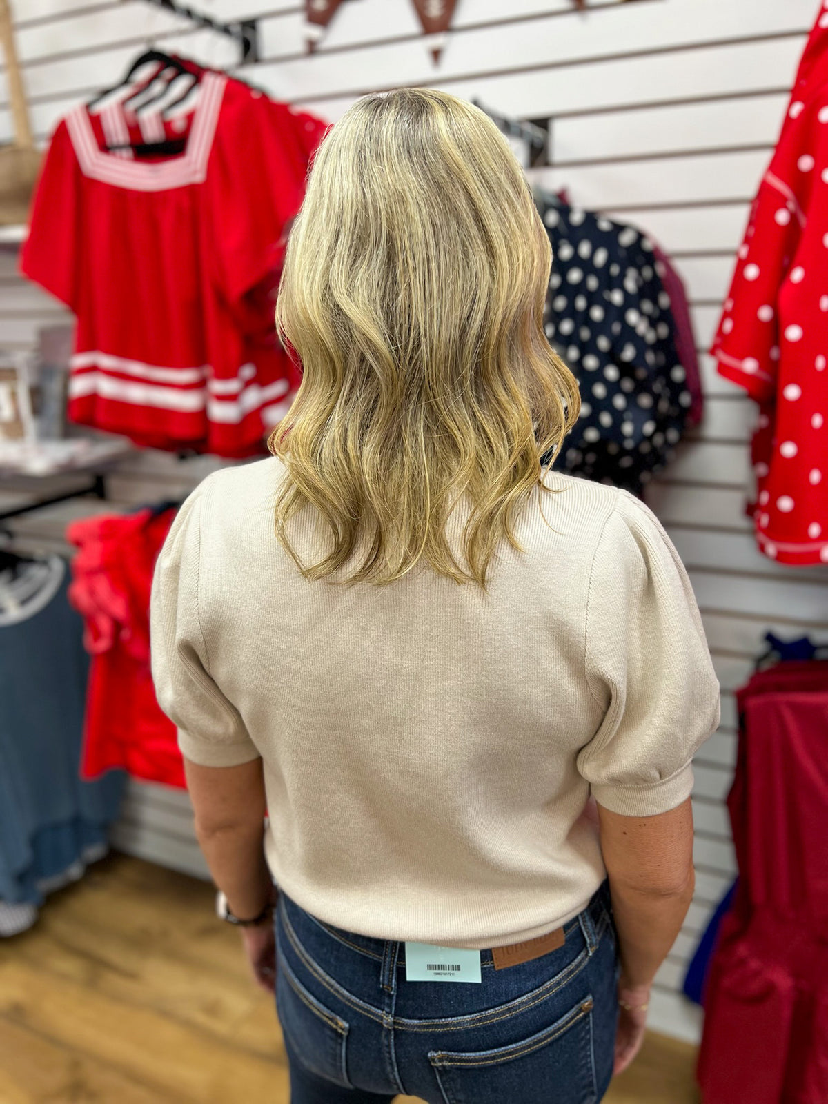Ecru short puff sleeve knit top shown from the back on a model