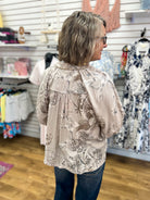 Taupe floral print blouse with 3/4 puff sleeves and gathered back yoke