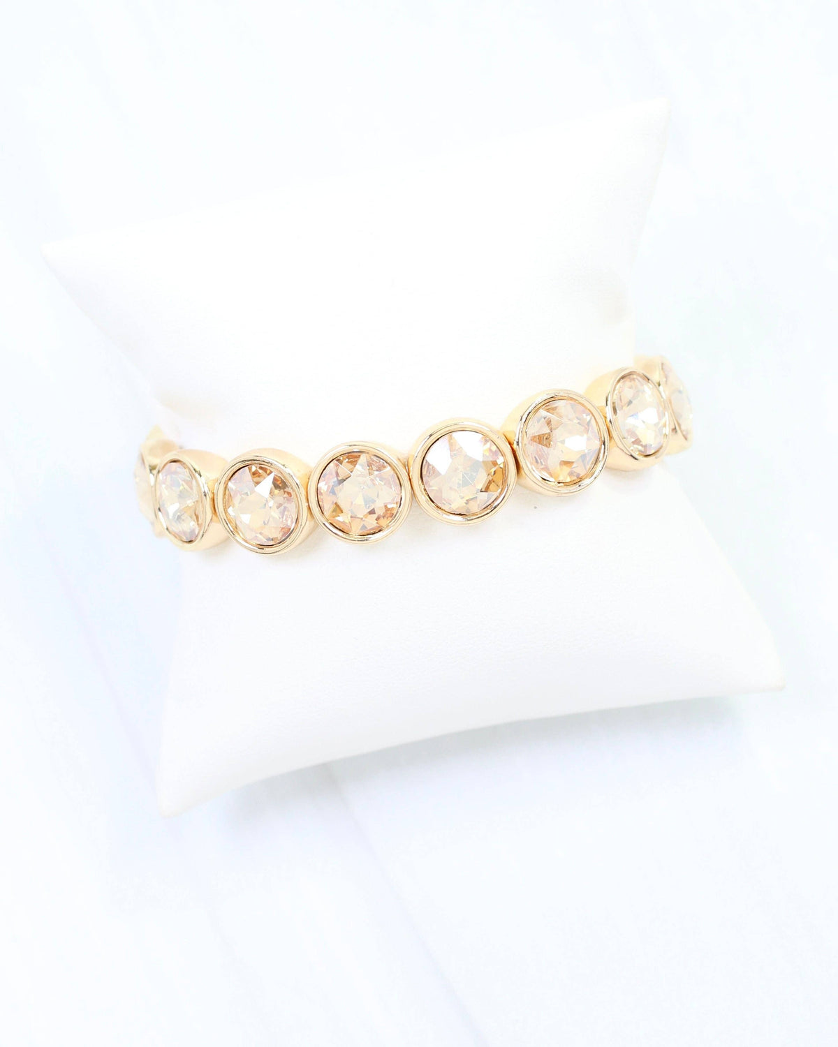 Gold stretch bracelet featuring round bezel-set champagne crystal stones in a row