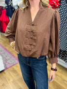 Brown v-neck puff sleeve blouse with frog closures and bubble hem by Entro