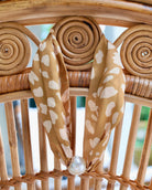 Taupe leopard print scarf necklace with pearl magnetic clasp on rattan chair