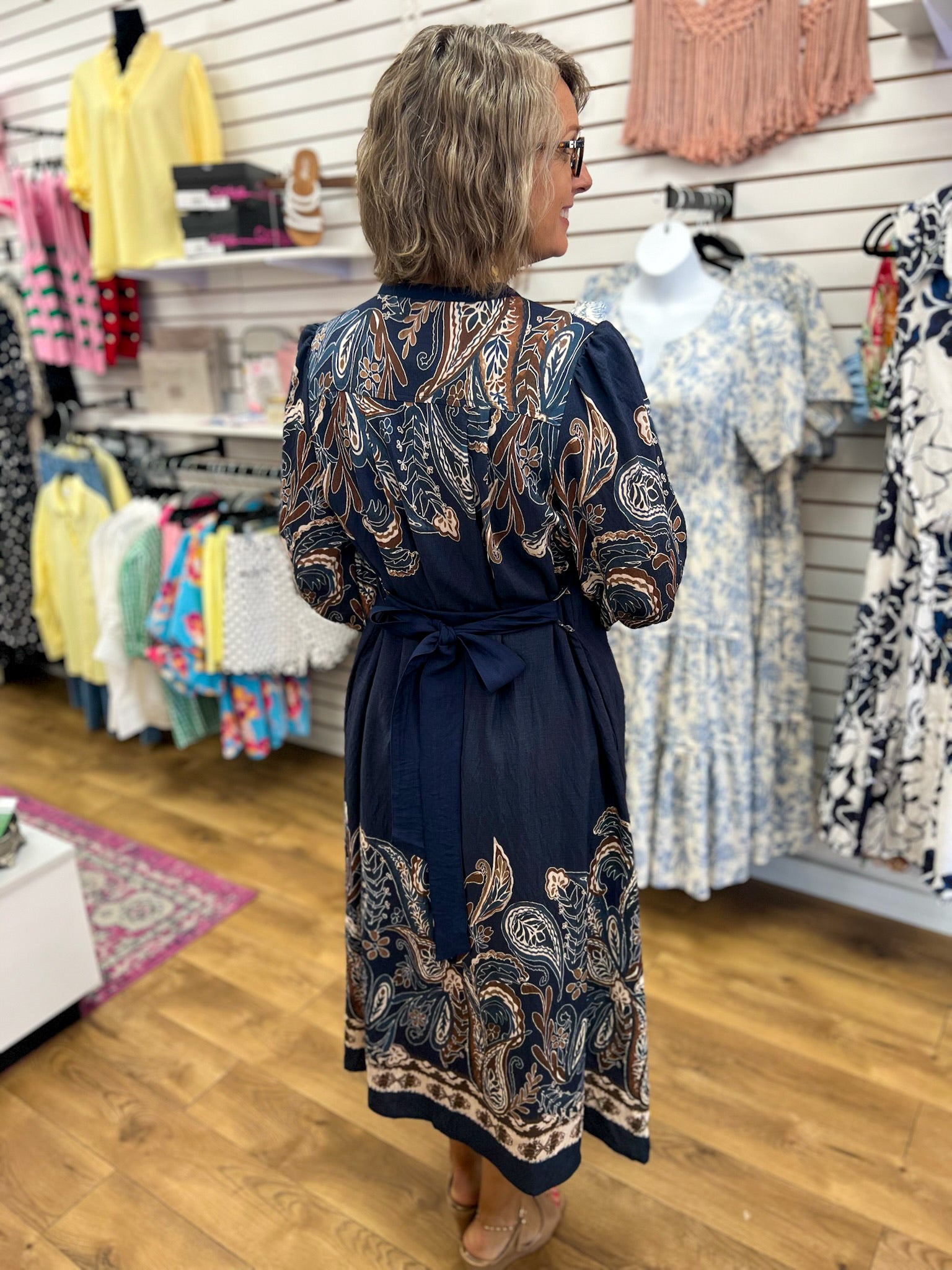 Navy paisley print midi dress with tie waist and long sleeves, back view