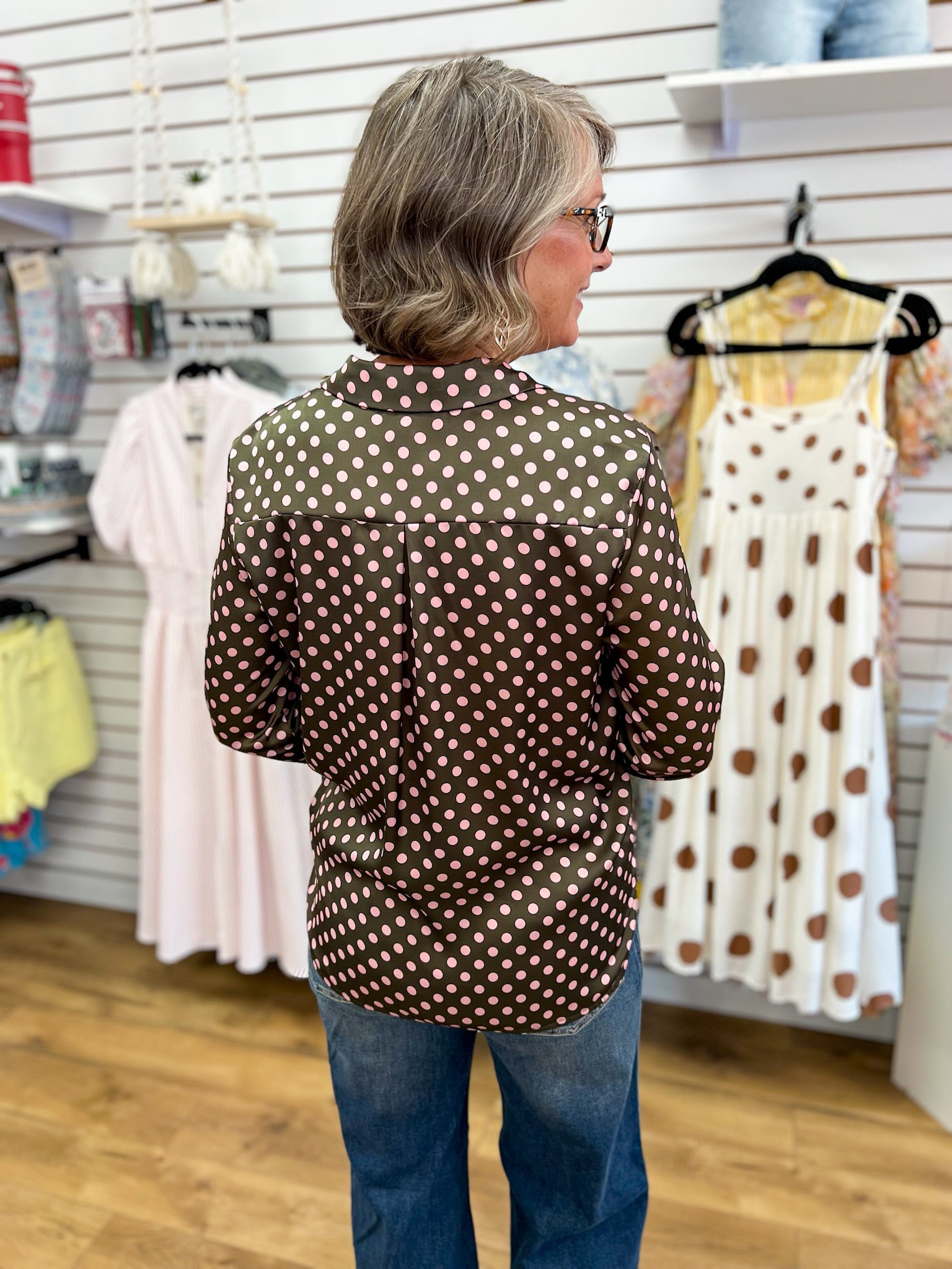 Olive satin button-up top with pink polka dots, long sleeves, worn with jeans