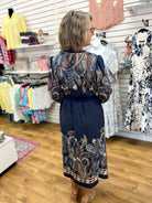 Navy paisley print midi dress with long sleeves and tied waist, back view