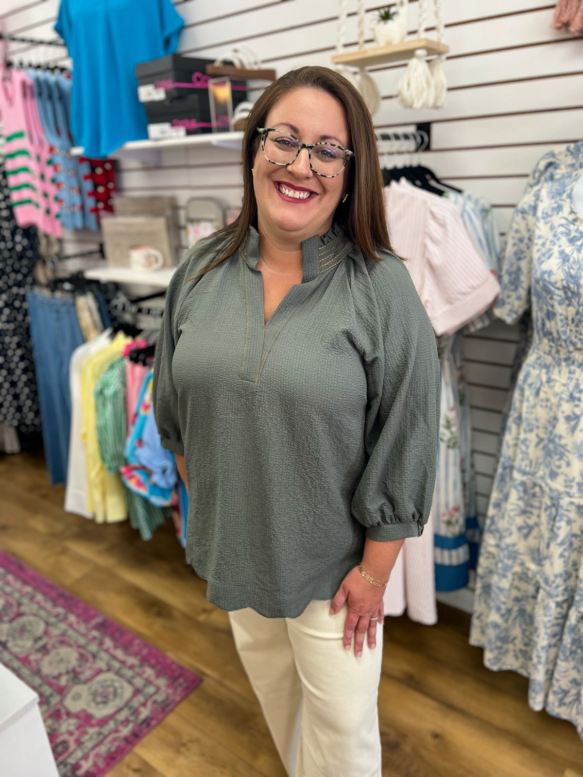 Olive grey v-neck top with 3/4 balloon sleeves, worn by brunette model in boutique