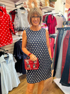 Navy blue sleeveless shift dress with white polka dots and pockets by She + Sky