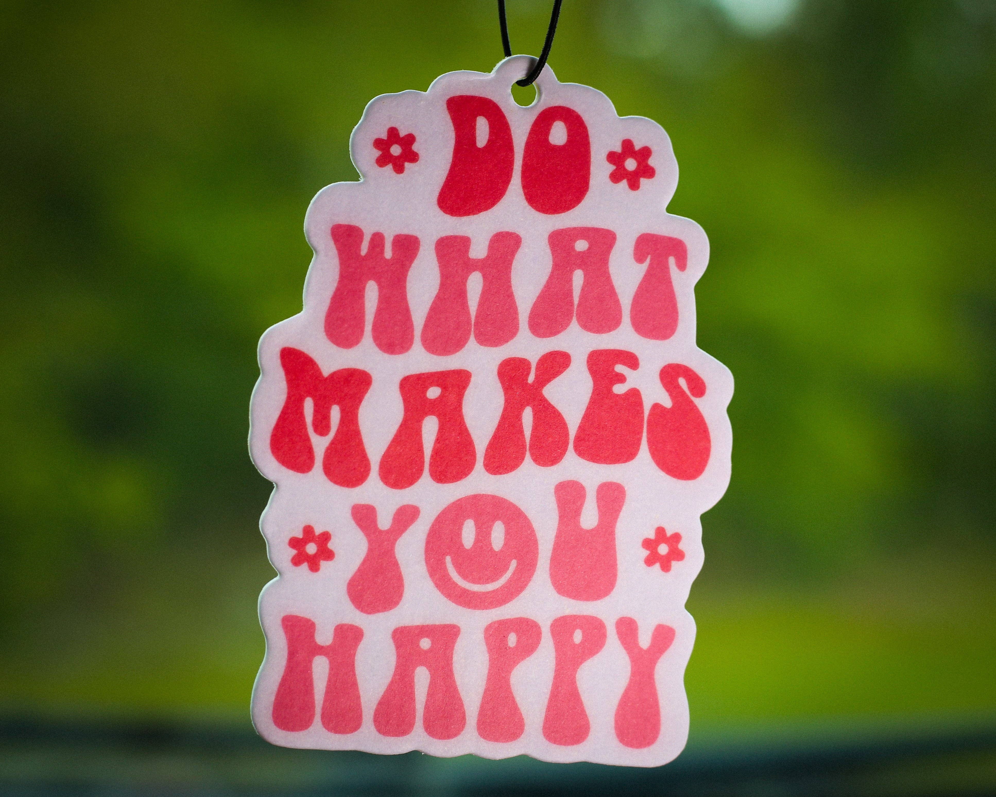 Pink and white car air freshener with retro groovy text Do What Makes You Happy