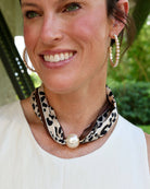 Leopard print scarf necklace with large magnetic pearl closure worn around neck