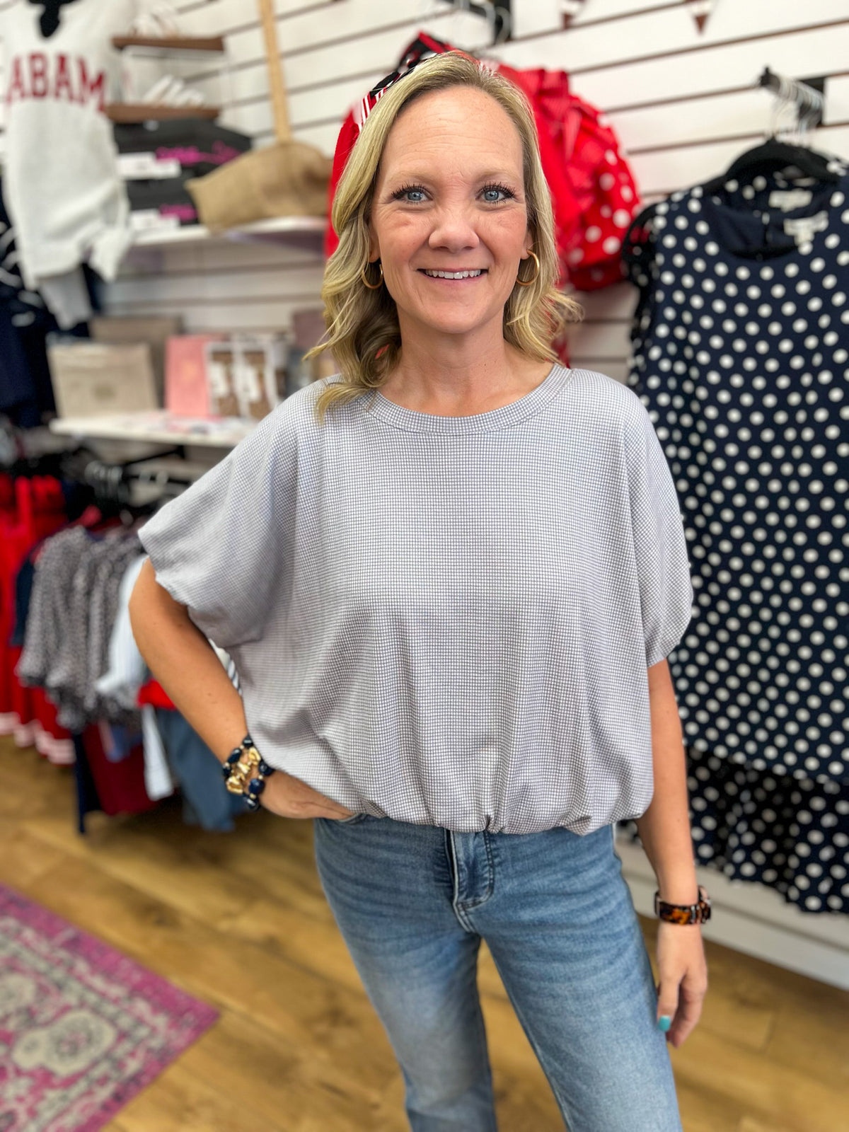 Grey mini checkered bubble hem top with short sleeves, worn with jeans.