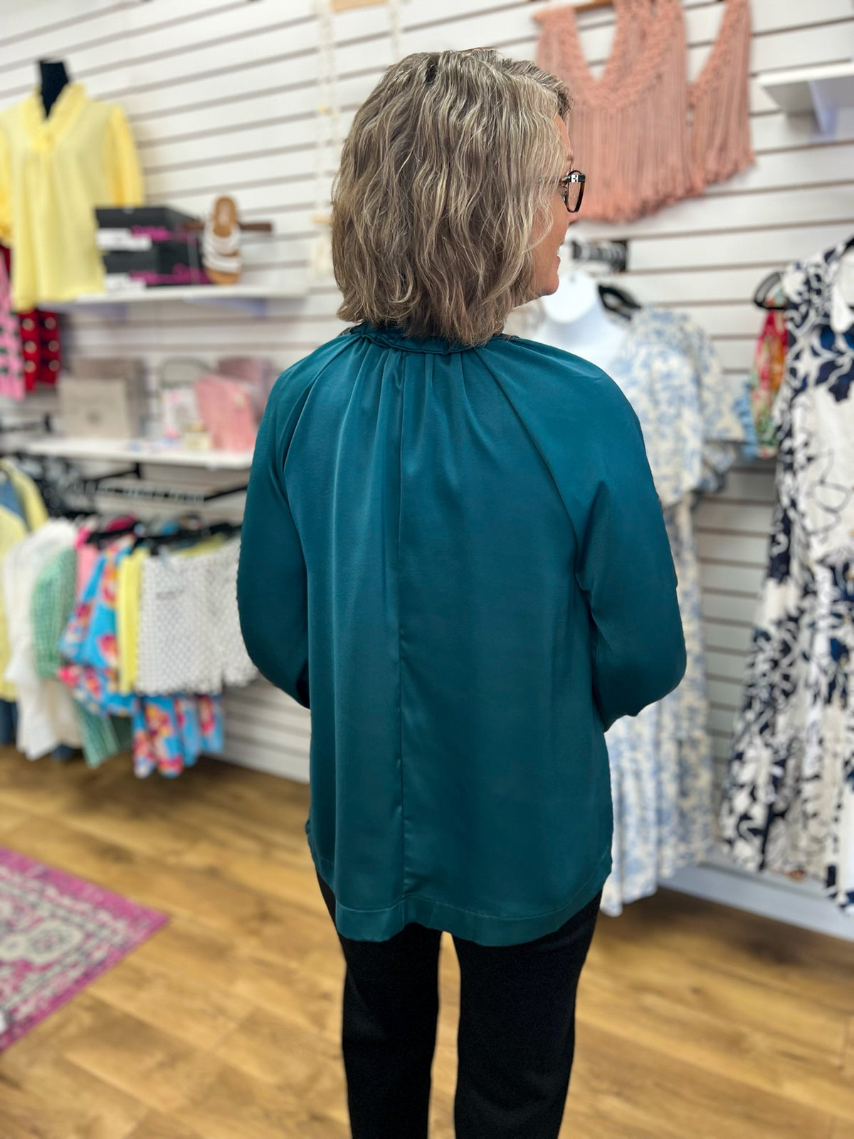 Teal green long sleeve tie neck blouse shown from the back on a model