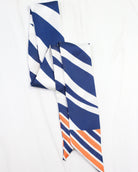 Navy blue white and orange diagonal striped skinny scarf laid flat