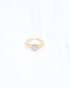 Gold adjustable ring with round CZ center stone and halo setting on white background