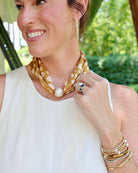 Taupe animal print silk scarf necklace with large magnetic pearl closure worn around neck