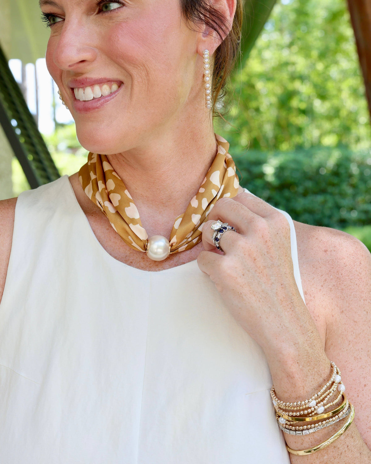 Taupe animal print silk scarf necklace with large magnetic pearl closure worn around neck