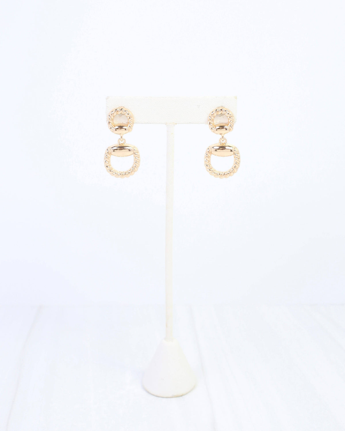 Gold drop earrings with braided rope detail and open horsebit ring pendant