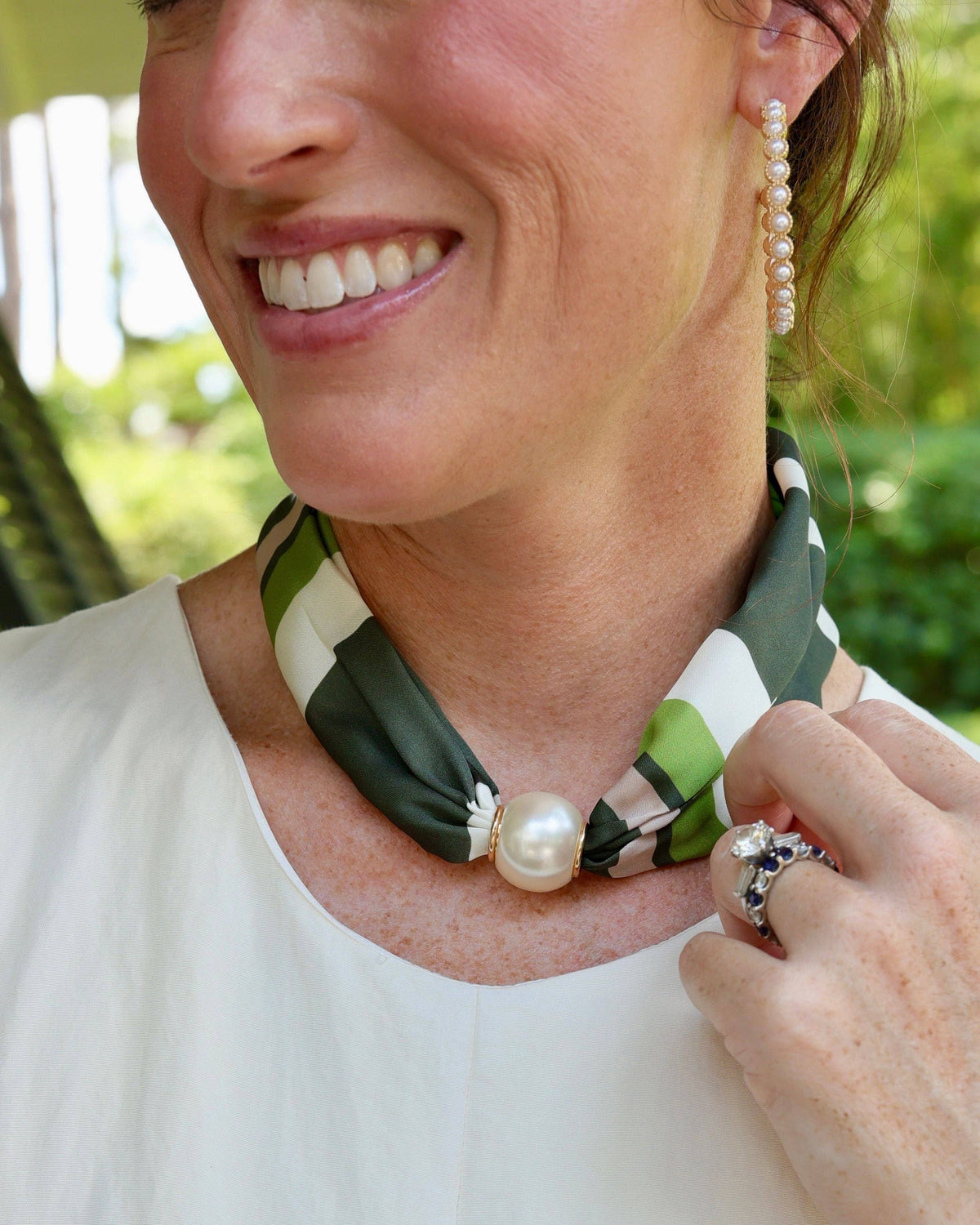 Olive green white striped scarf necklace with large magnetic pearl closure on woman