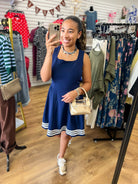 Navy sleeveless fit-and-flare dress with square neckline and white contrast stripe hem