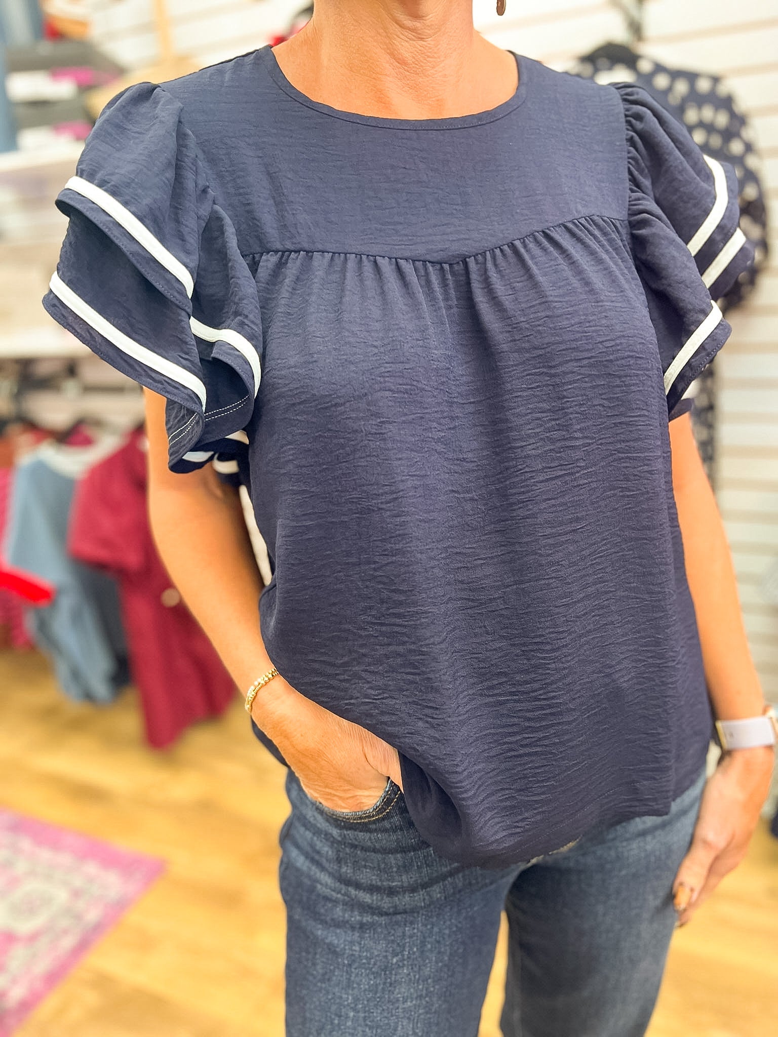 Navy blue ruffle short sleeve top with white contrast piping stripe detail