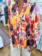 Umgee ecru floral smocked V-neck button-up blouse in purple, orange, and pink