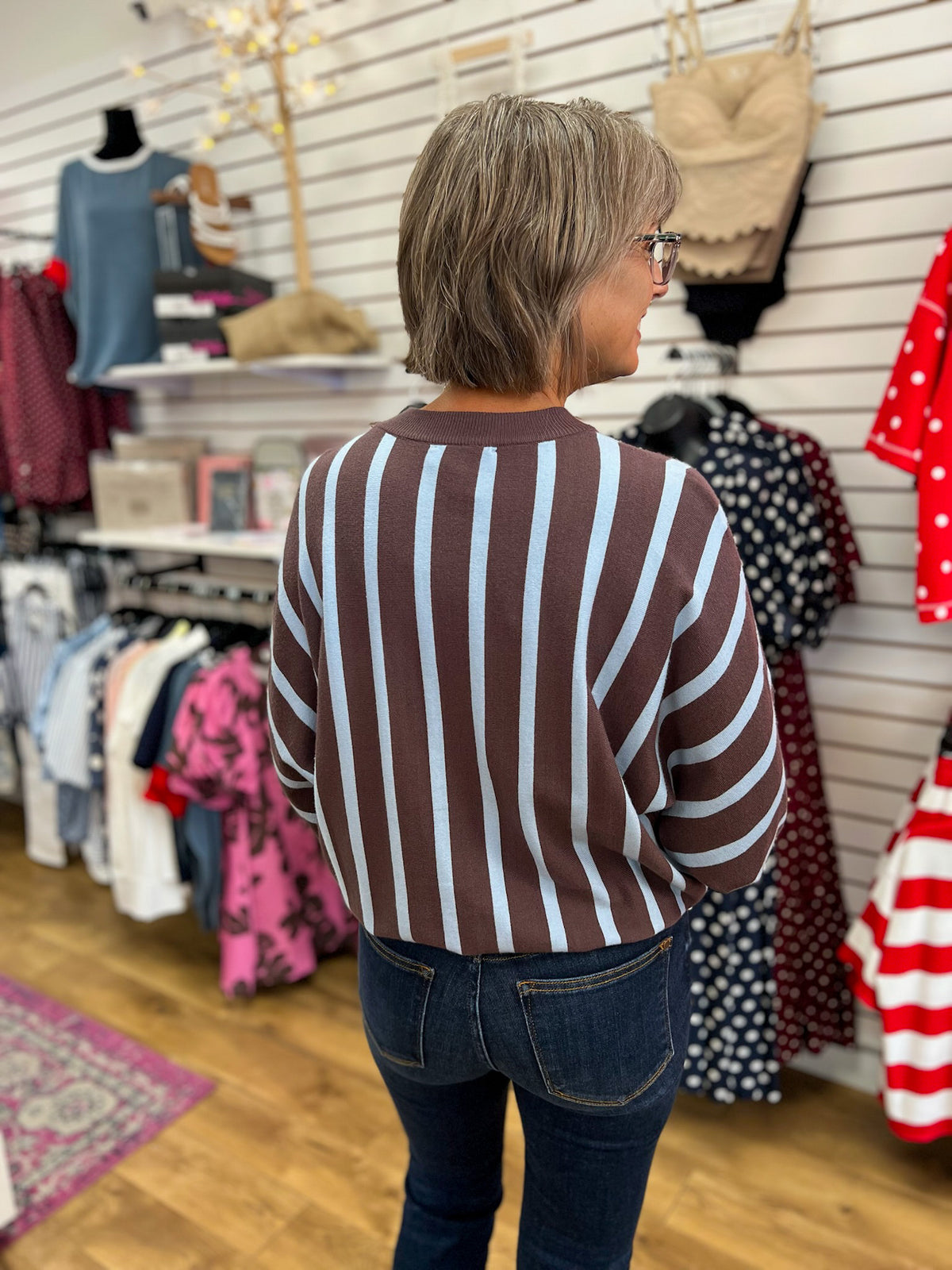 Ash brown and light blue vertical striped sweater with long batwing sleeves, back view