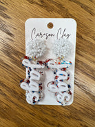 White beaded stud earrings with red blue glitter acrylic script word dangles